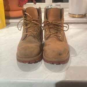 Bruna boots från Timberland - Säljer ett par klassiska bruna boots från Timberland. Skorna har snörning och är tillverkade i skinn med en robust sula. Perfekta för höst och vinter. Nästan oanvända, men har blivit lite missfärgade. 
