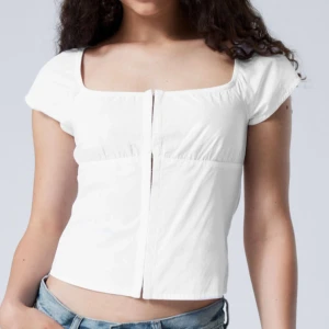 Vit blus från Weekday - Snygg vit blus från Weekday med korta ärmar och en fyrkantig urringning. As snygg fest topp! Den e för liten för mig! nypris 400 o jag säljer för 350