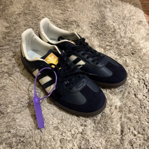Adidas Samba OG Night Navy Cream White - Säljer ett par riktigt snygga adidas samba skor. De är köpta från PrimeStreetwear för ca 2700 kr, mitt pris är 1299 kr. De är helt oanvända med taggen på (se bild). De är i storlek 46 men sitter mindre och skulle passa runt 44-44. Säljer pga för små. Box och kvitto ingår, skriv privat för fler bilder eller frågor!