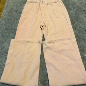 Rosa manchesterbyxor - Snygga rosa  manchesterbyxor med hög midja och rak passform. Perfekta för en stilren look. Byxorna har knapp och dragkedja framtill.