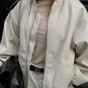 Oversized bomberjacka från NA-KD - Snygg beige bomberjacka från NA-KD med dragkedja framtill och en praktisk ficka med dragkedja på ärmen. Jackan har en stilren design och är perfekt för en trendig look. Köpt på NA-KD för 1099kr men har inte kommit till användning🥳