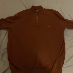 Brun tröja med dragkedja från Boss - Säljer en stilren brun tröja från Boss med halv dragkedja. Perfekt för kyligare dagar och ger en elegant touch till din outfit. Ny pris 1800 lägsta bud 900