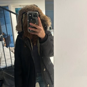 Svart parkajacka från Svea - Säljer en svart parkajacka från Svea med pälskantad huva. Jackan har långa ärmar och flera praktiska fickor. Perfekt för kyliga dagar. Priset går att diskutera!