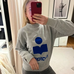 Grå sweatshirt från Isabel marant - Säljer en grå sweatshirt från Isabel marant med en stor blå logotyp på framsidan. Tröjan är i nyskick.