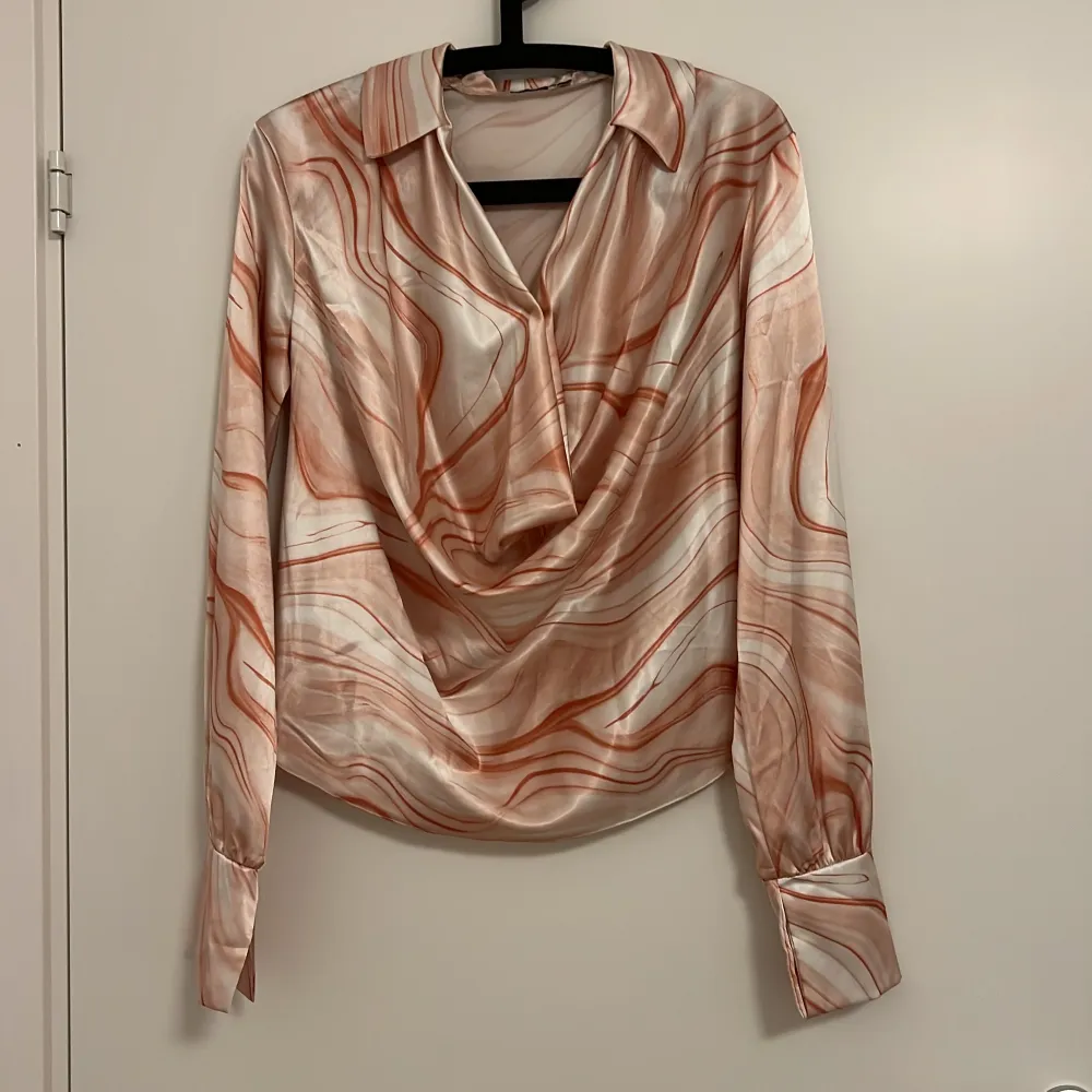 Jättefin och elegant blus i satin från Nelly. Gammal kollektion. Passar XS-S. Puserot.