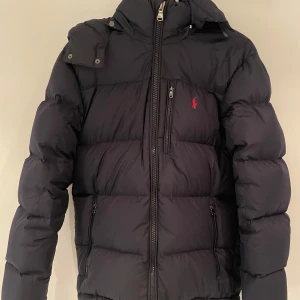 Polo Ralph Lauren Vinterjacka - Säljer en snygg vinterjacka från Polo Ralph Lauren i mycket bra skick. Perfekt för kalla vinterdagar! Slutsåld i storlek S nästan överallt. Kvitto finns. Nypris ligger på 5799. Mitt pris 3399
