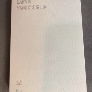 BTS - Love Yourself HER - Säljer albumet 'Love Yourself: Her' med en stilren vit design och holografiska detaljer. Innehåller en CD, fotokort, andra samlarobjekt och en fotobok med bilder på medlemmarna. Perfekt för fans av K-pop men framförallt BTS. Albumet är i nytt skick och kommer med originalförpackning.