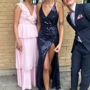 Balklänning mörkblå - Säljer min vackra balklänning, den är mörkblå med blåa paljetter på som bildar typ blommor på klänningen. Klänningen är från showpo. Använd en gång, Inga skador på klänningen den är som ny. Jag är 175, nypris 2000kr