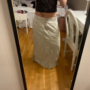 Beige långkjol - Säljer en snygg beige långkjol i bomull. Den är lite skrynklig på bilderna men det är bara att stryka den☺️. Kjolen har en klassisk design med dragkedja fram och en bekväm passform🤍