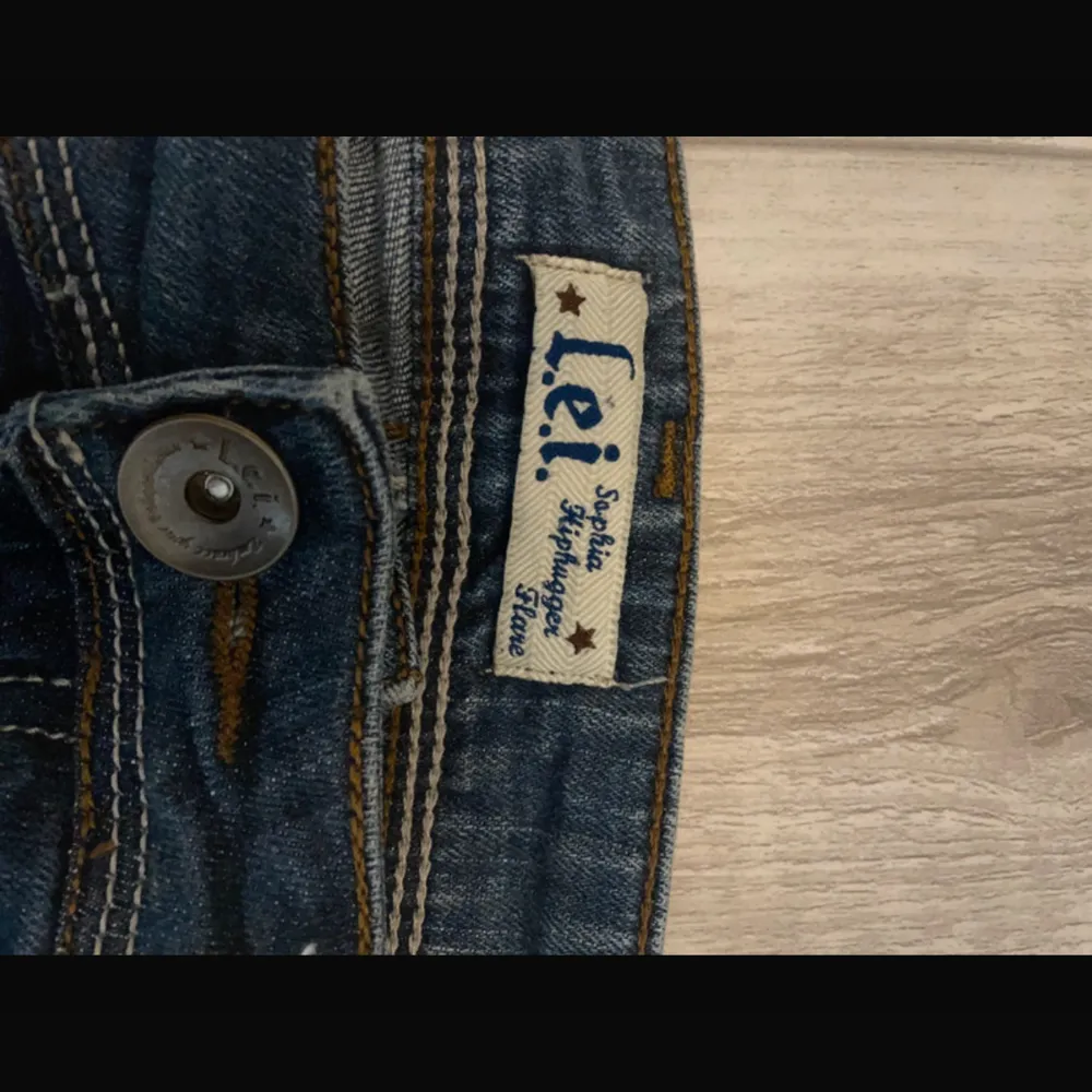 Säljer ett par snygga blå bootcut jeans från l.e.i.  Jättefina men va lite för stora i midjan på mig. Fina detaljer på bakfickorna. Midjemått: 74 cm. Jeans & Byxor.