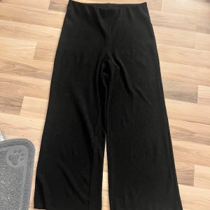 Svarta vida byxor - Säljer ett par svarta vida byxor i ribbat material. De är högmidjade och har en loose passform, perfekt för både vardag och fest. Byxorna är i mycket bra skick och superbekväma att ha på sig. Passar perfekt till höst och vinter! 🖤