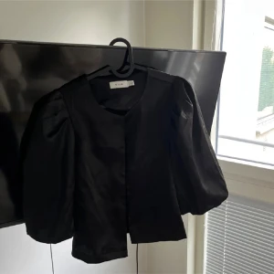 Svart blus från Vila - Säljer en elegant svart kavaj från Vila. Den har en stilren design med trekvartsärmar och en rund halsringning. Perfekt för både fest och vardag. Passar bra till både jeans och klänning. 🖤