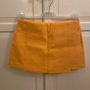 Skorts från Zara  - Säljer denna snygga skorts från Zara. Aldrig använd. Storlek M. Färgen är orange. Dragkedja på sidan. Undershorts. 