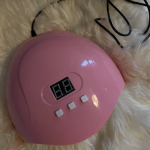 Rosa UV/LED lampa  - Säljer min rosa UV/LED lampa med 54W, då jag fått en annan. Men denna är så gott som ny, inga synliga märken och fungerar som den ska. Har även bara hunnit använda den ett fåtal gånger. - Sladd medföljer men ej adapter. UV/LED lampan har sensorer så man inte behöver klicka på knapparna ifall man inte vill. Men utöver det så har den 3 olika knappar med olika timer - 30sekunder, 60sekunder, 90sekunder. 