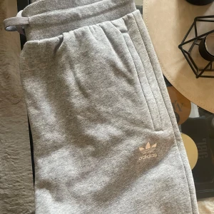 Adidas mjukisbyxor  - Grå adidas mjukisbyxor, mudd nertill. Storlek 158. Använda men fint skick! 