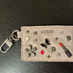 Guess korthållare - Korthållare i skinn från Guess med nyckelring. Använd i okej skick. Mått 11,5 cm x 7,5 cm 
