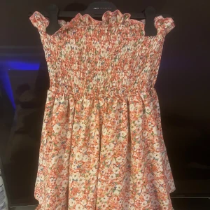 Tub klänning  - En rosa blommig tub klänning med volanger