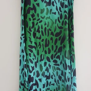 Klänning - Grön långklänning med svart mönster på, aldrig använd.