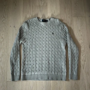 Ralph Lauren Kabelstickad Tröja - En fräsch kabelstickad tröja ifrån Ralph Lauren perfekt inför Hösten/ Vintern. Vid minsta fundering hör av er!