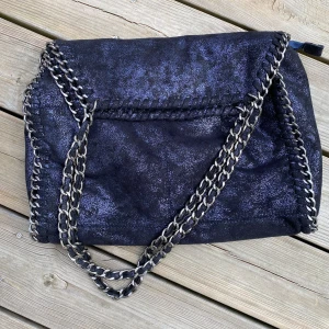 Väska Stella Maccartny-liknande - Liknar Stella Maccartney. Perfekt väska för både skola och annat. Mörkblå skimrande.  Fin och fräsch i omhändertaget skick. 