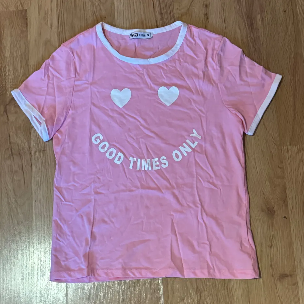 En gullig baby pink T-shirt med tryck på smiley pch text ”Good times only”. I begagnad skick behövs stryka bara. Storlek S kan även passa XS.  Katter finns i hemmet. T-shirts.