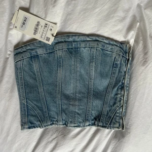 Oanvänd Zaratopp - Oanvänd Zarakorsettopp i jeansmaterial. Storlek XS. Nyskick. Frakt tillkommer.