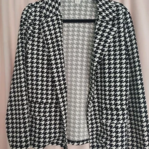 Svartvit rutig kavaj från Shein - Säljer en snygg svartvit rutig kavaj från Shein. Perfekt för att ge din outfit en stilren touch. Kavajen har ett klassiskt hundtandsmönster och är långärmad. Materialet är "mjukis". Passar både till vardags och fest!