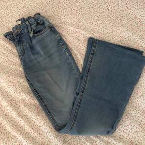 Lågmidjade flare jeans från Lindex kids i storlek 170. Ganska använda. Sydda längst ner för att anpassa min längd (160). På ena benet har jeansen slitits (se bild) men ser ganska bra ut ändå. Annars är jeansen inte så slitna.