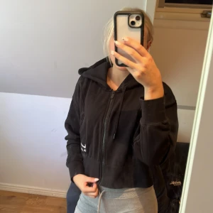 Svart hoodie från Nike - Säljer en svart hoodie från Nike Air. Den är superbekväm och perfekt för både chill och träning. Hoodien har en dragkedja framtill och en klassisk luva. Den är i bra skick och har en snygg, enkel design med Nike-loggan nertill