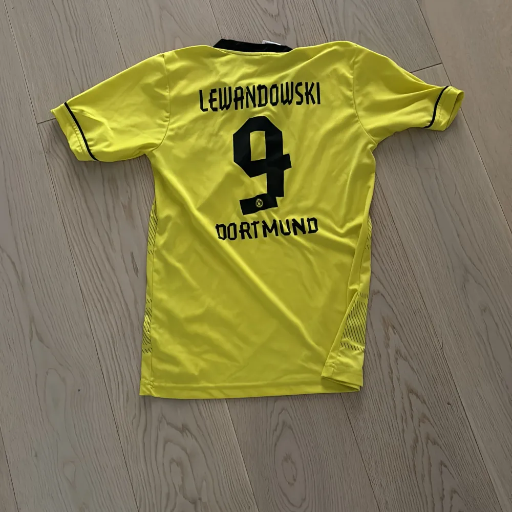 En helt sprillans ny Dortmund tröja med lewandowsksi på ryggen. En gammal design men helt ny tröja helt enkelt. Den har inga hål såklart och är i storlek XS-S. Priset är inte hugget i stenen.. T-shirts.