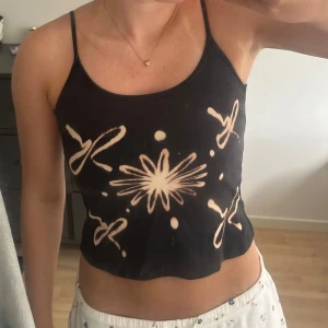 Svart linne med detaljer  - Säljer detta svarta linne med detaljer liknande fyrverkerier. Sömmen under armhålorna har gått om men syr igen det  innan den skickas. Skulle uppskatta strl XS men passar mig som har strl S. Är det något för dig? Hör av dig!!💓💓 Pris kan diskuteras:)