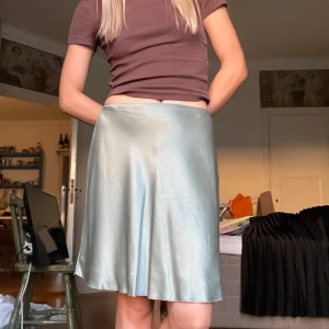 Vacker grön skilkeskjol - superfin grön kjol i silkesimiterat tyg, sitter så fint på kroppen. Är i fint skick 🤍