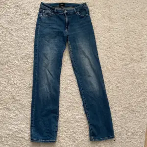 Säljer ett par snygga blå jeans från Vero Moda i storlek 32/32 De har en klassisk straight fit och är tillverkade i slitstarkt denim. Perfekta för både vardag och fest! 🥳Tyvärr en reva bak. Se bild. 