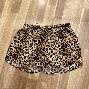 Leopardmönstrade shorts - Snygga leopardmönstrade shorts med elastisk midja och knytband. Perfekta för en avslappnad dag eller en rolig fest! Från New Yorker i storlek 38. Oanvända!! 