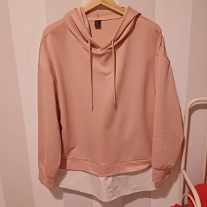 Beige hoodie med vit detalj - Säljer en superfin beige hoodie med en cool vit detalj längst ner. Den har en skön luva och långa ärmar, perfekt för en avslappnad stil. Materialet känns mjukt och bekvämt, perfekt för höst och vår. Passar perfekt till jeans eller leggings!