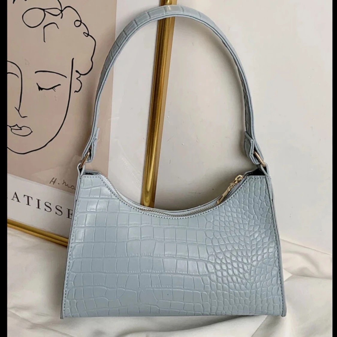 Ljusblå axelväska med krokodilmönster