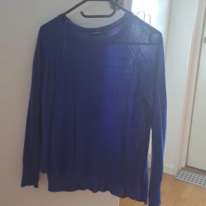 Blå långärmad tröja från Zara - Säljer en snygg blå långärmad tröja från Zara. Den är perfekt för både vardag och lite finare tillfällen. Tröjan har en enkel och stilren design med en rund halsringning. Materialet är mjukt och bekvämt, vilket gör den skön att ha på sig hela dagen.