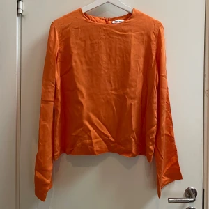 Blus Carin Wester - Orange blus från Carin Wester. Slits vid ärmslut för fin detalj