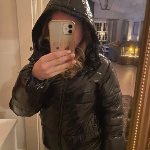 Svart glansig vinter jacka  - Bra skick. Från Nelly. Väldigt varm. 