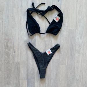 Svart bikini med glittriga detaljer - Svart bikini, överdel och underdel (glittrig underdel) i strl XS. Helt nya. 