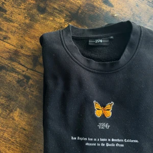Svart 274 tröja - Svart tjocktröja från märket 274 med broderad fjäril och textdesign. Köpt på Asos men kommer tyvärr inte till användning längre. Storleken är XS men modellen är väldigt oversize och sitter mer som M/L. Fler bilder kan fixas vid efterfrågan!