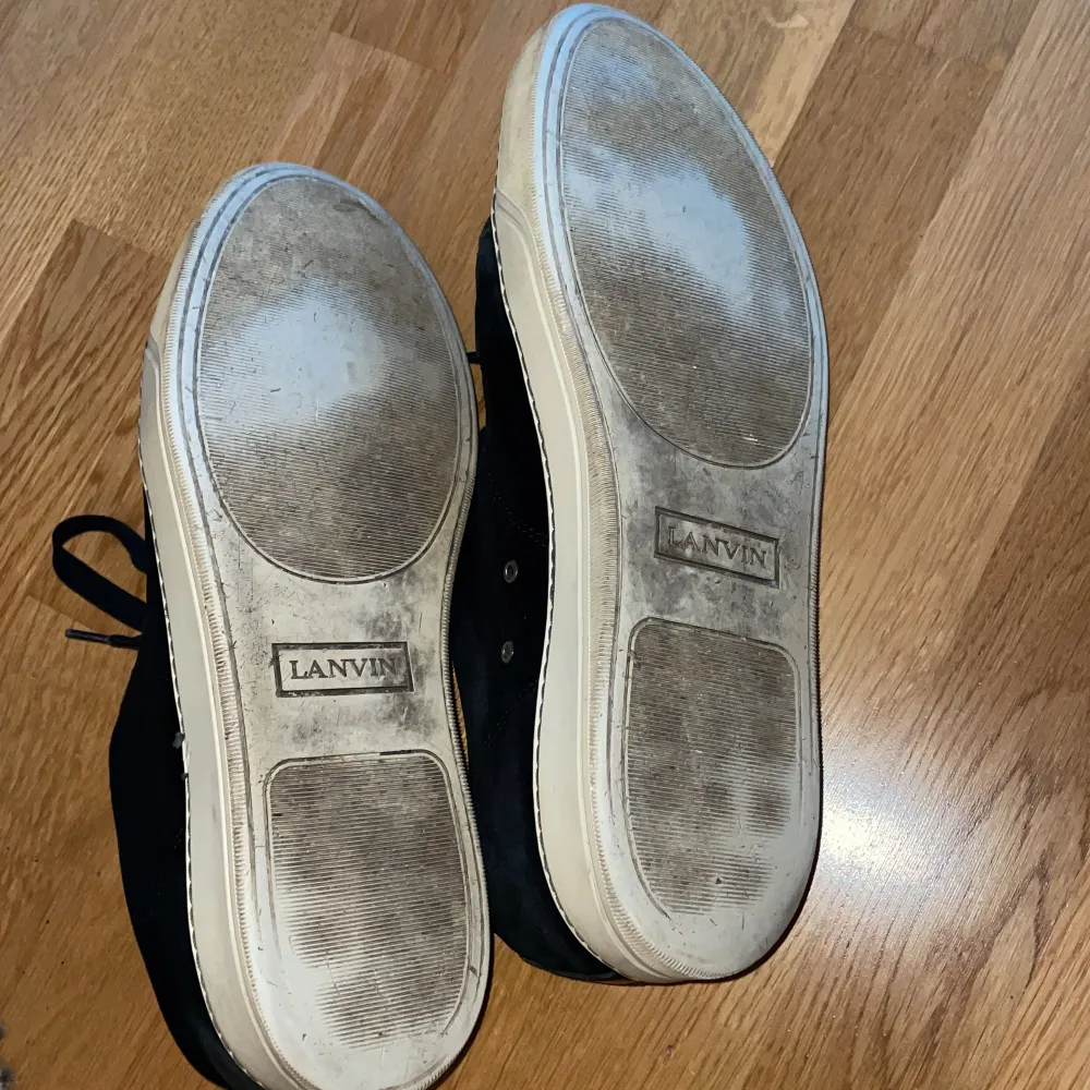 Säljer ett par svarta sneakers från Lanvin i bra skick. Skorna har en glansig finish och klassisk snörning. De har en vit sula som visar lite användning men är fortfarande i gott skick.  Priset är ej hugget i sten och kan sänkas vid snabb affär!!. Skor.