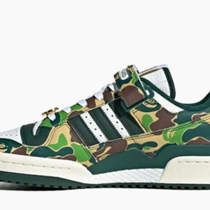 Adidas Low Bape 30th Anniversary Green Camo - Snygga Adidas sneakers i camouflage-mönster med gröna och bruna nyanser. De har vita snören och de klassiska tre ränderna i svart. Perfekta för en cool och avslappnad stil. Skorna har en robust sula och är i mycket bra skick.