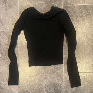Svart långärmad topp från Bershka - Säljer en stilren svart långärmad topp från Bershka i storlek XS. Perfekt för både vardag och fest! Toppen är i ett mjukt och stretchigt material som sitter skönt på kroppen. Passar utmärkt till höst- och vintergarderoben. 🖤