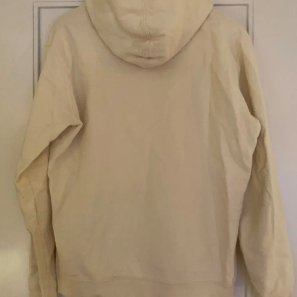 Säljer en stilren beige hoodie från NN07 i mycket bra skick. Den har en klassisk design med känguruficka och justerbar huva med dragsko. Perfekt för både vardag och mysiga stunder. Texten 'No Nationality' pryder bröstet för en minimalistisk look.. Tröjor & Koftor.