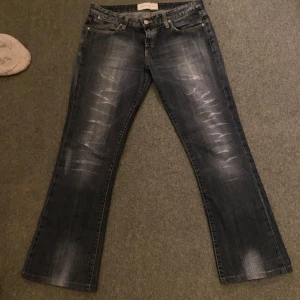 Mörkblå jeans med slitningar - Säljer ett par mörkblå bootcut jeans med slitningar fram och bak, står ingen storlek men skulle säga S/M