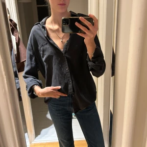 Mörkgrå skjorta  - En grå jeansskjorta?! Lite osäker men ni kan se färgen och tyget på sista bilden