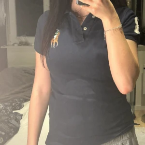 Ralph lauren - En Ralph lauren piké i mörkblå i storlek xs, med två slits vid sidan och siffran tre på ena axlen, inga defekter alls 