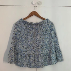 Blommig kjol från Vero Moda - Superfin blommig kjol från Vero Moda i storlek M. Den har ett härligt blått mönster med små gula blommor och en volangdetalj längst ner. Perfekt för vår och sommar! 🌼Midjemått 36cm, stretchigt midja. 48cm lång. 