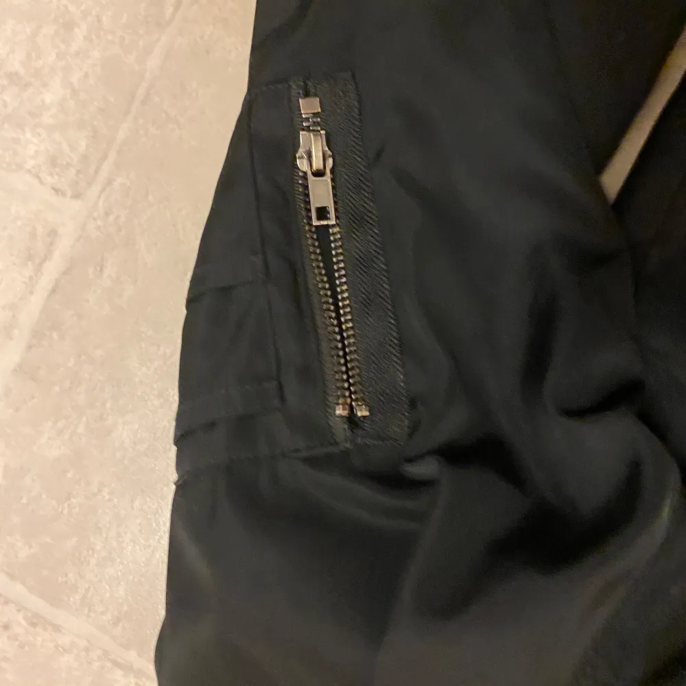 Säljer en snygg svart bomberjacka från KappAhl i storlek L Jackan har en dragkedja framtill och en cool ficka med dragkedja på ärmen. Perfekt för höst och vår! 🖤. Takit.